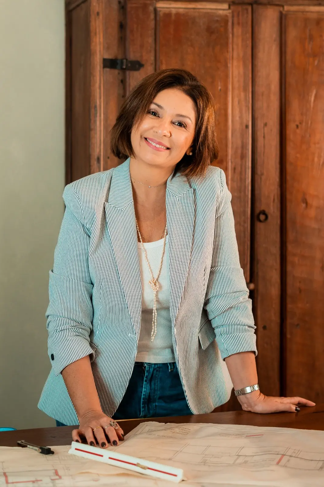 Mônica Carvalho em seu ambiente de trabalho, diante de um projeto arquitetônico